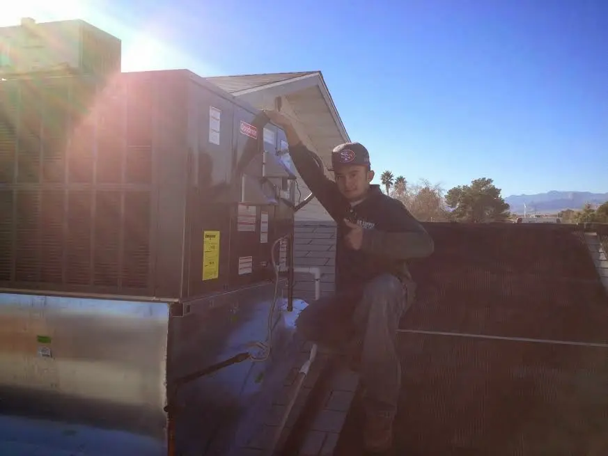 HVAC technician performing AC Tune-Up on a rooftop unit in Petaluma