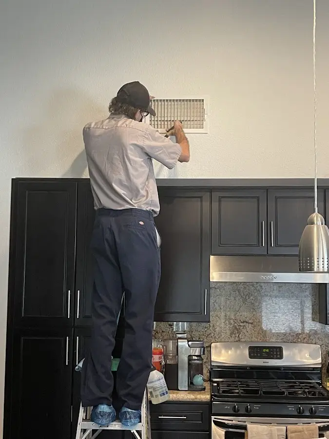 Technician inspecting an air vent during HVAC service in Petaluma
